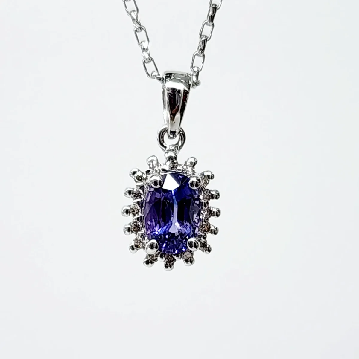 9ct White Gold 1.06ct Ceylon Sapphire with 0.10ct Diamond Halo Pendant