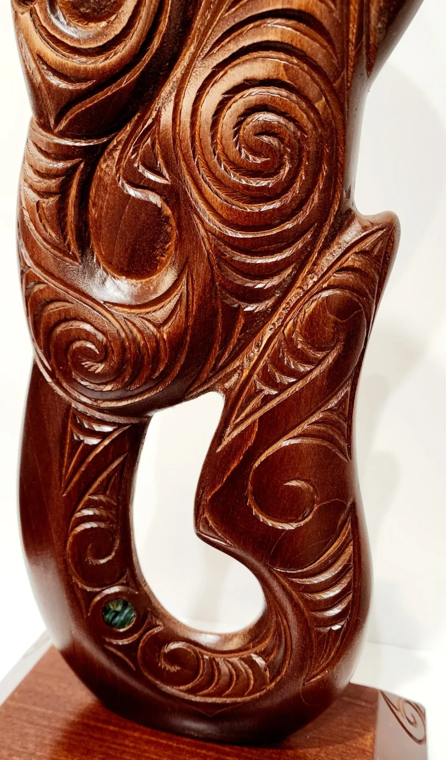 Large Carved Maori Hei Matau (Fish Hook) from Kauri Wood with Paua Shell Eyes on Stand
