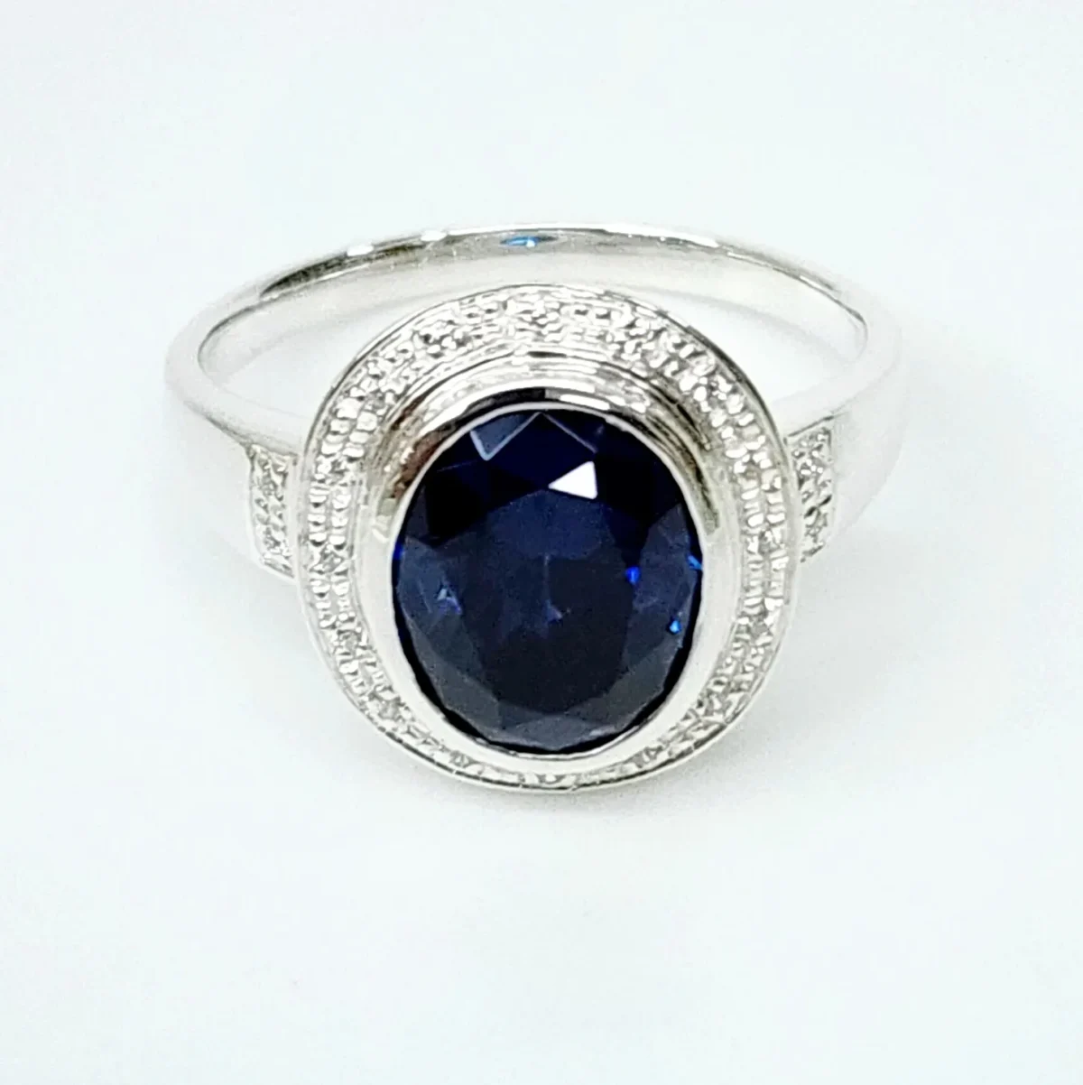 Sterling Silver 10mm x 13mm Ocal Cut Bezel Set Blue CZ and Halo CZ Setting Ladies Dress Ring