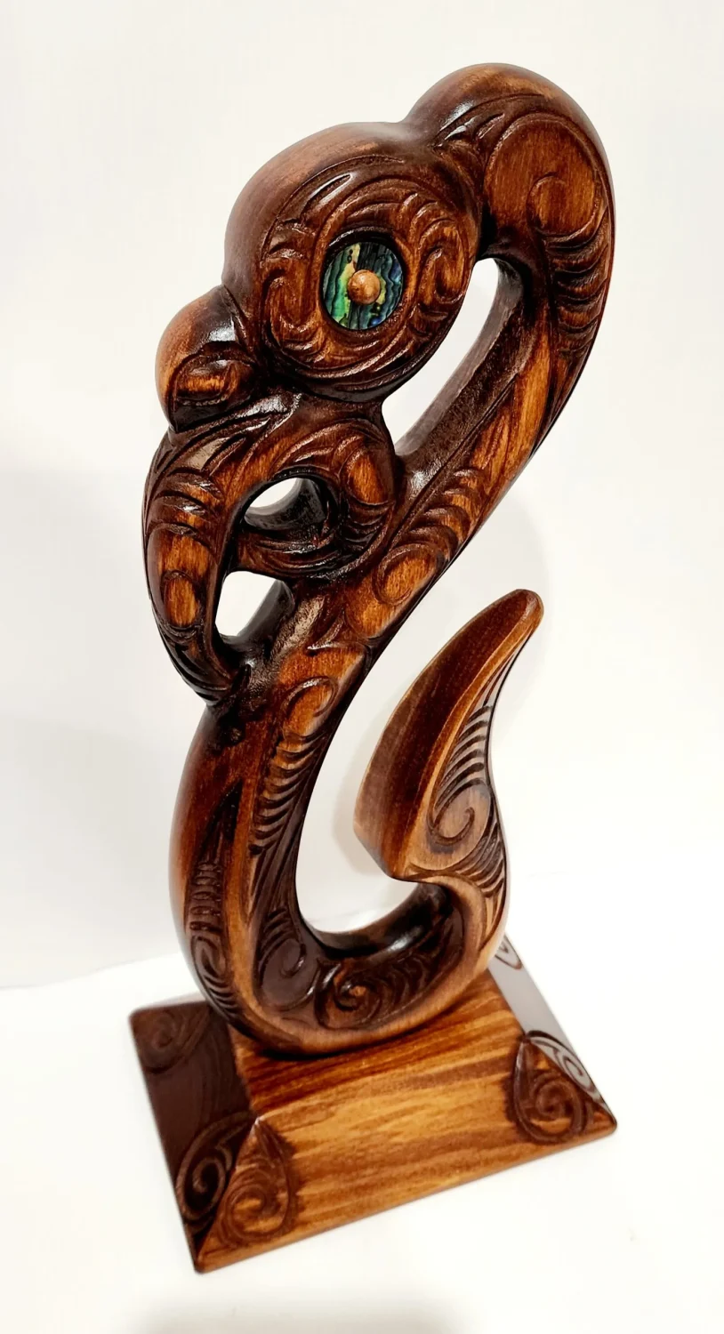 Wooden Carved Maori Fish Hook with Paua Shell Eyes on Stand