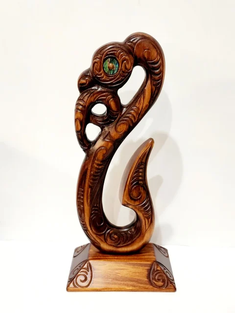 Wooden Carved Maori Fish Hook with Paua Shell Eyes on Stand