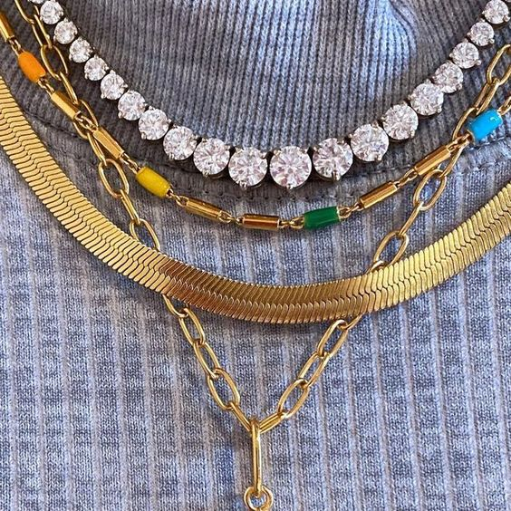 women wearing gold huggie earrings